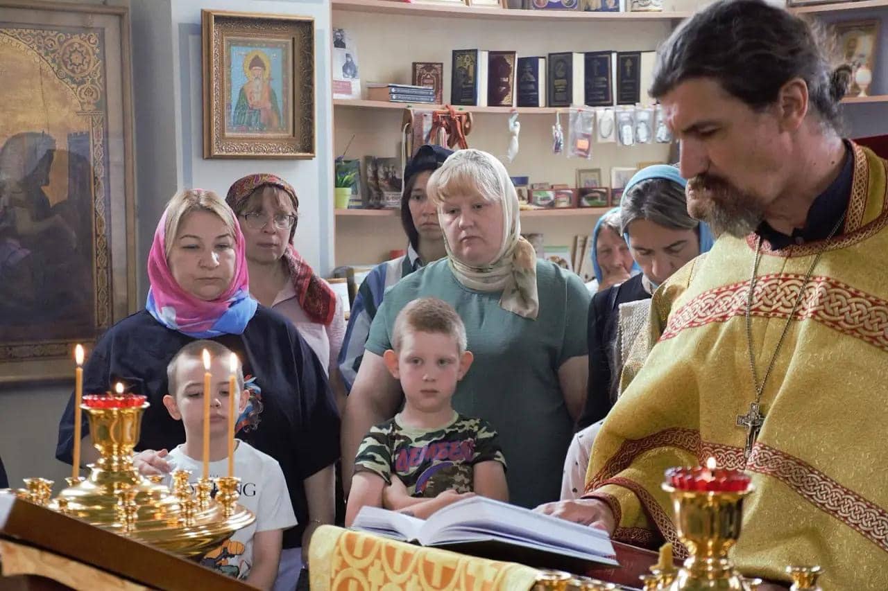 Священнослужитель и прихожане за молитвой